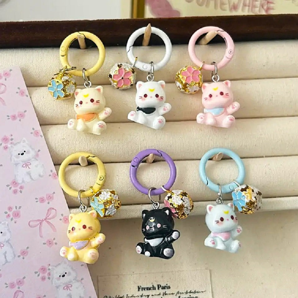 un porte-clés en forme d'un chat kawaii coloré tout mignon, il est accompagné de son grelot en forme de sakura.