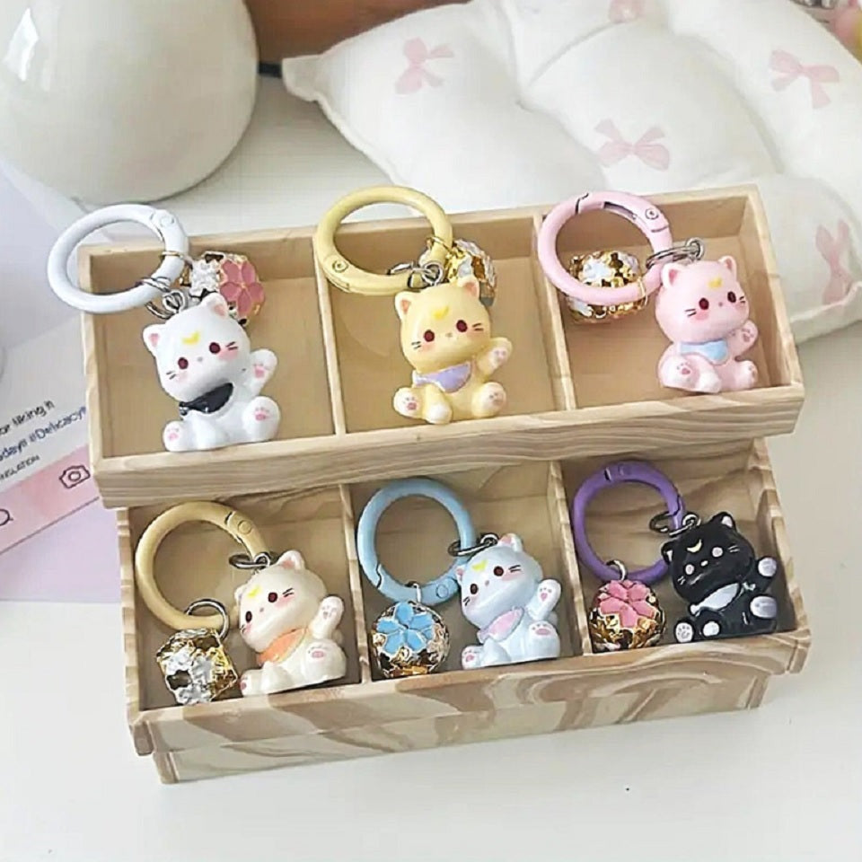 un porte-clés en forme d'un chat kawaii coloré tout mignon, il est accompagné de son grelot en forme de sakura.