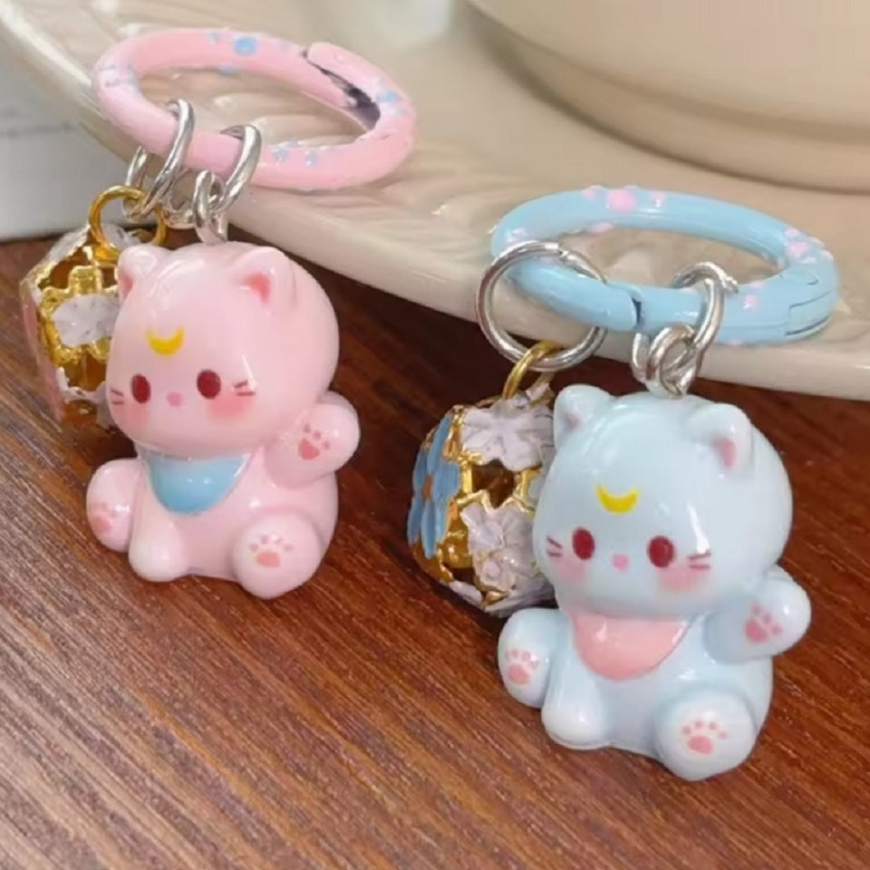 un porte-clés en forme d'un chat kawaii coloré tout mignon, il est accompagné de son grelot en forme de sakura.