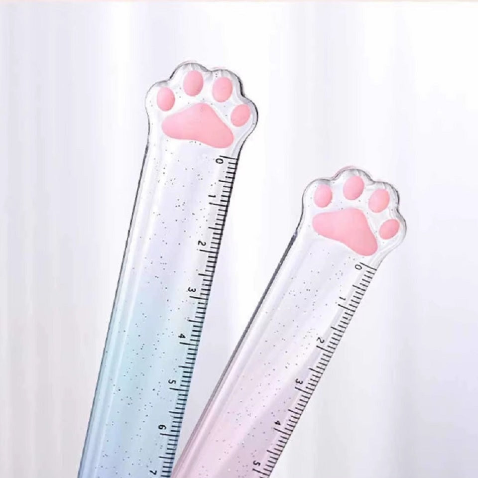 une règle pailletée en forme de patte de chat toute mignonne avec ses coussinets roses. graduée jusqu'à 15 cm, elle est trop kawaii avec son dégradé de couleur pastel