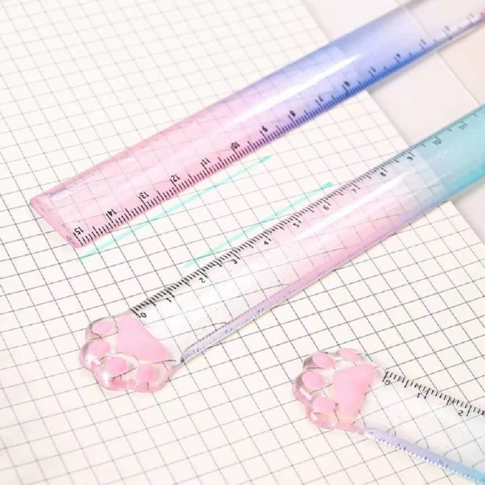 une règle pailletée en forme de patte de chat toute mignonne avec ses coussinets roses. graduée jusqu'à 15 cm, elle est trop kawaii avec son dégradé de couleur pastel