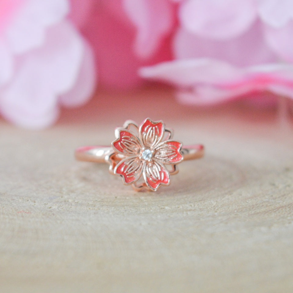une jolie bague rotative en coloris rose gold en forme de fleur de sakura. Elégance et raffinement se combinent dans ce bijou aux effet anti stress et apaisant.