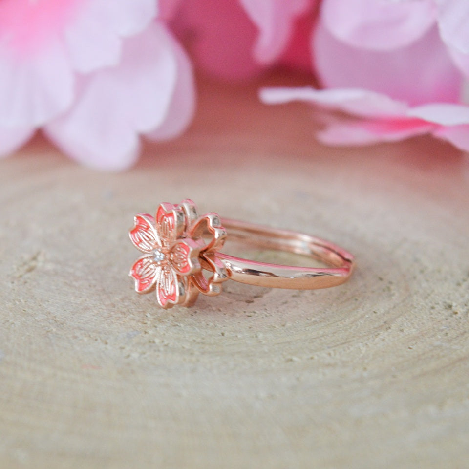 une jolie bague rotative en coloris rose gold en forme de fleur de sakura. Elégance et raffinement se combinent dans ce bijou aux effet anti stress et apaisant.