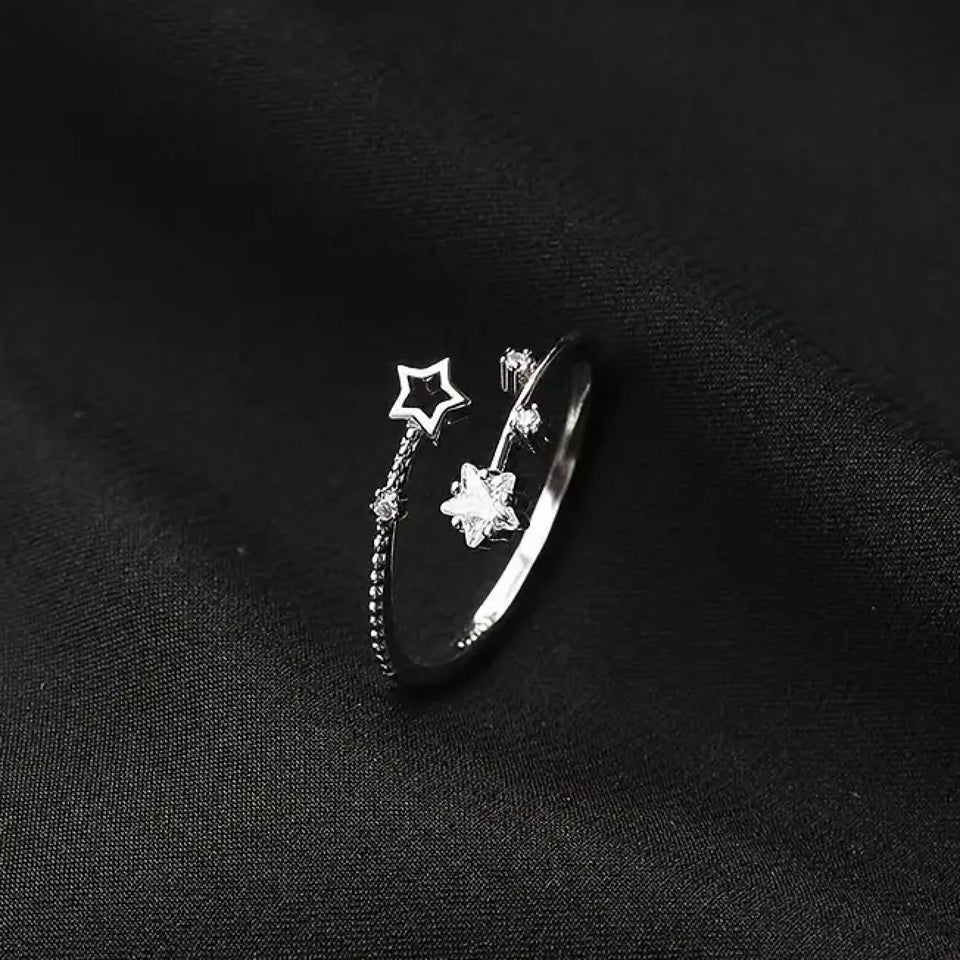 une bague argentée et réglable en forme d'étoiles filantes et scintillantes