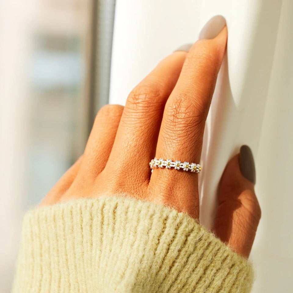 une jolie bague argentée et réglable marguerites. Une guirlande de marguerites fait le devant de la bague