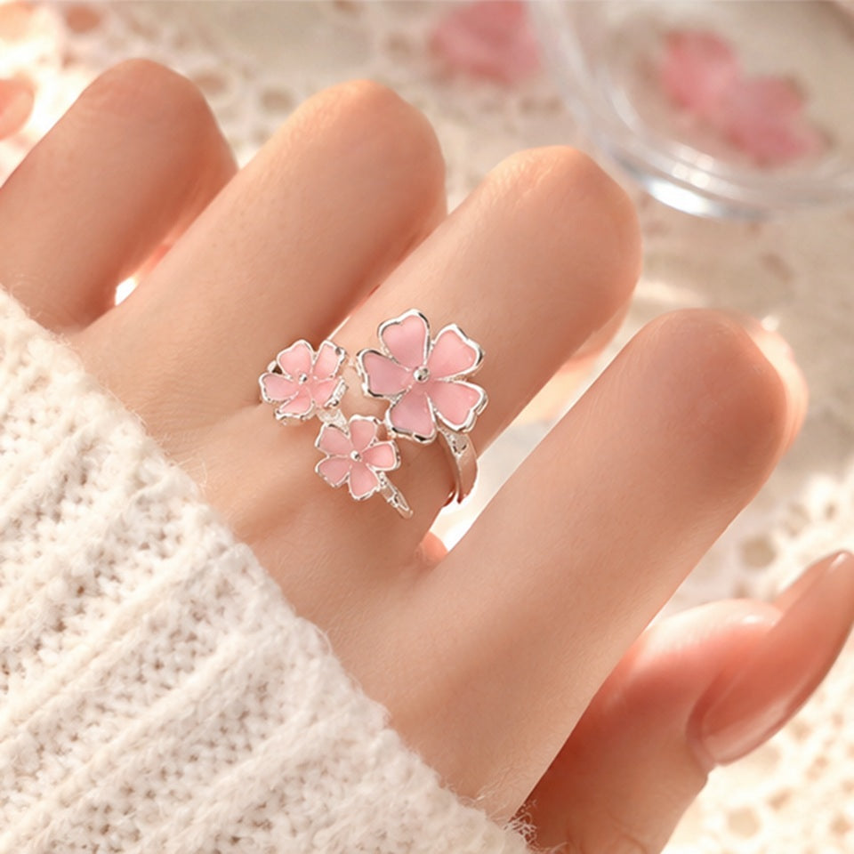 une jolie bague argentée réglable en forme de trois fleurs de sakura roses. Jolie design romantique et floral