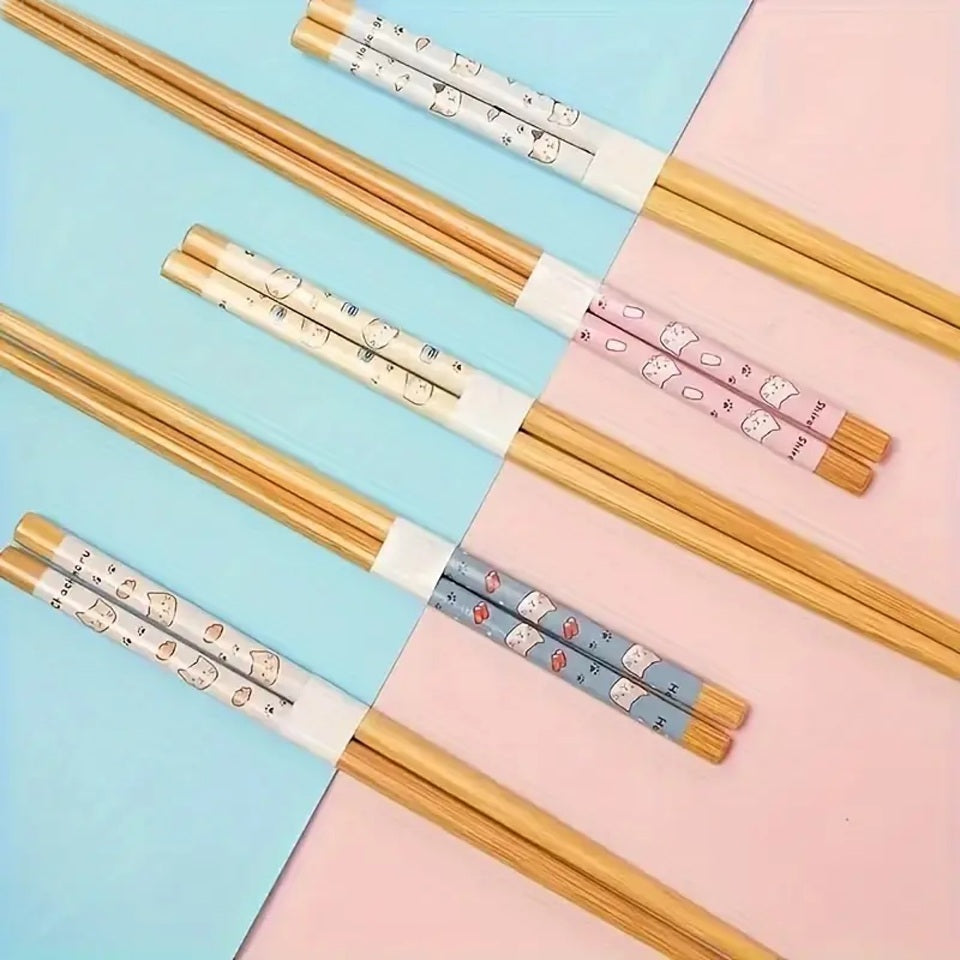 des baguettes japonaises au motif de petits chats et de nourriture. Le design est amusant et très mignon. En bambou, elles sont durables et réutilisables.