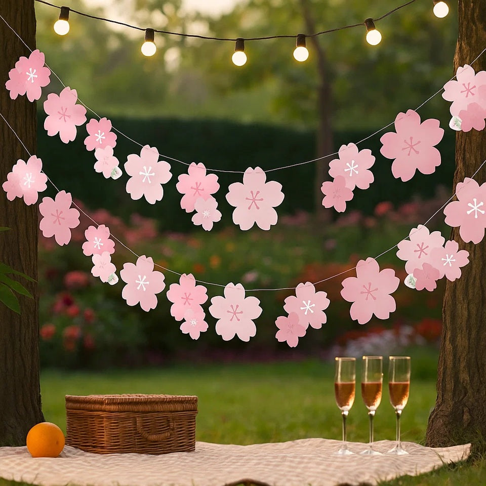 une banderole en papier formée de fleurs de sakura rose. A suspendre avec sa cordelette fournie. Elle ajoute une touche florale et mignonne à une pièce ou un extérieur.