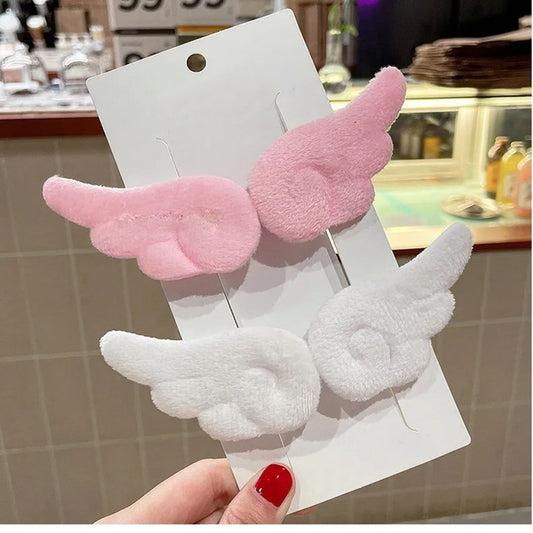 une paire de barrettes à cheveux en forme d'ailes d'ange blanches ou roses. Pour un look kawaii et romantique elles sont parfaites. En matière peluchée, elles sont toutes douces.