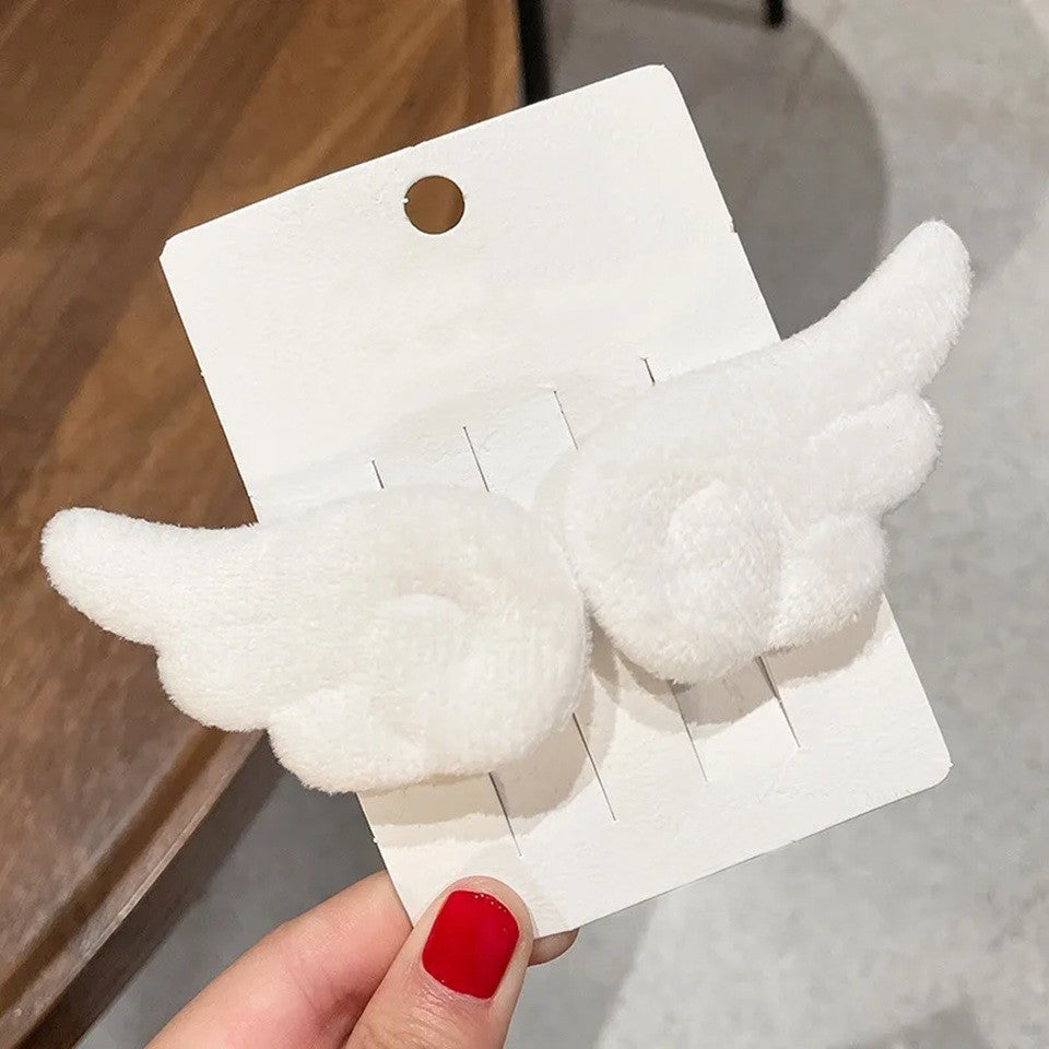 une paire de barrettes à cheveux en forme d'ailes d'ange blanches ou roses. Pour un look kawaii et romantique elles sont parfaites. En matière peluchée, elles sont toutes douces.