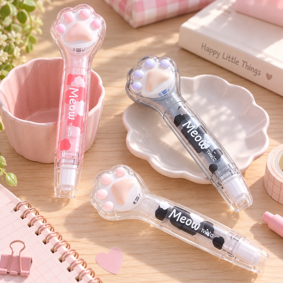 Blanco ruban correcteur kawaii en forme de patte de chat, décliné en rose et gris, présenté dans un joli décor de papeterie pastel avec lumière naturelle