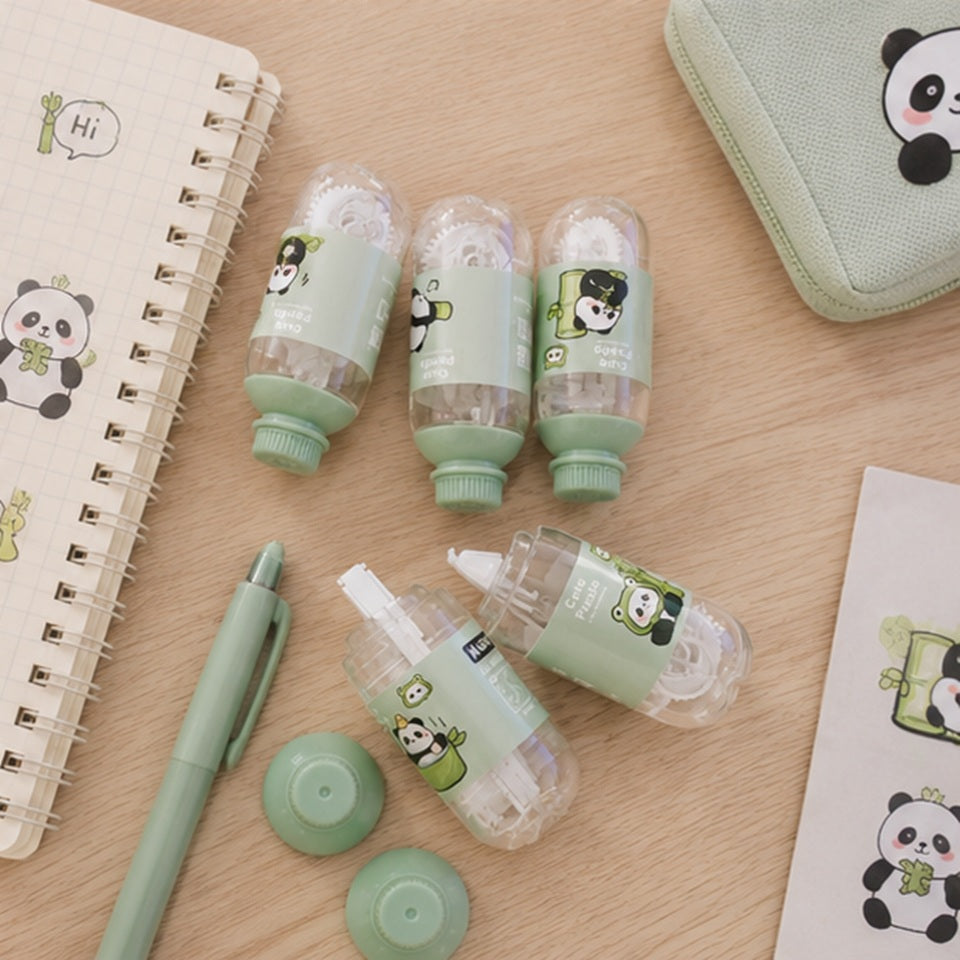 Lot de correcteurs à ruban kawaii en forme de petite bouteille avec motifs panda, présentés dans un joli décor pastel avec carnet, stylo et accessoires de papeterie. Correcteurs décoratifs et pratiques pour l'école, le bureau ou le bullet journal.