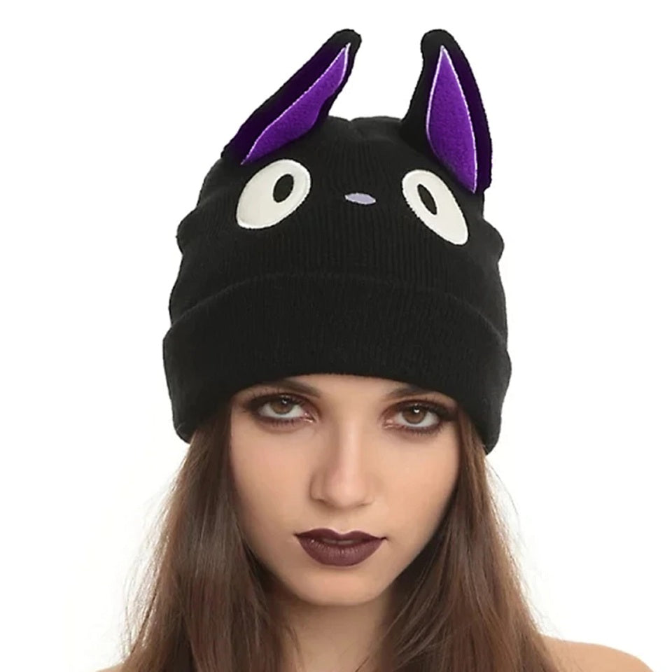 un bonnet représentant le chat noir Jiji dans Kiki la petite sorcière. Il possède deux grandes oreilles violettes