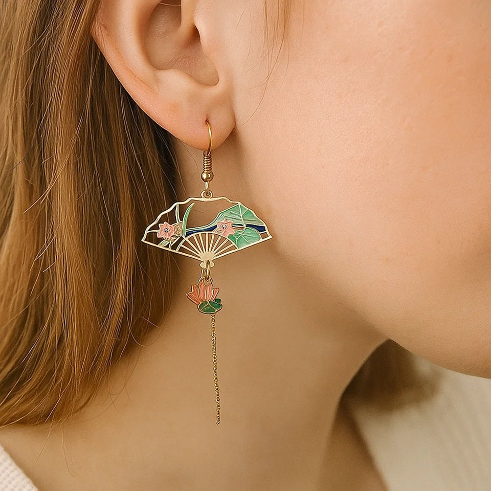 une paire de boucles d'oreilles asymétriques composées d'une carpe koï rouge et blanche et d'une perle ainsi que d'un éventail au motif de nénuphar.