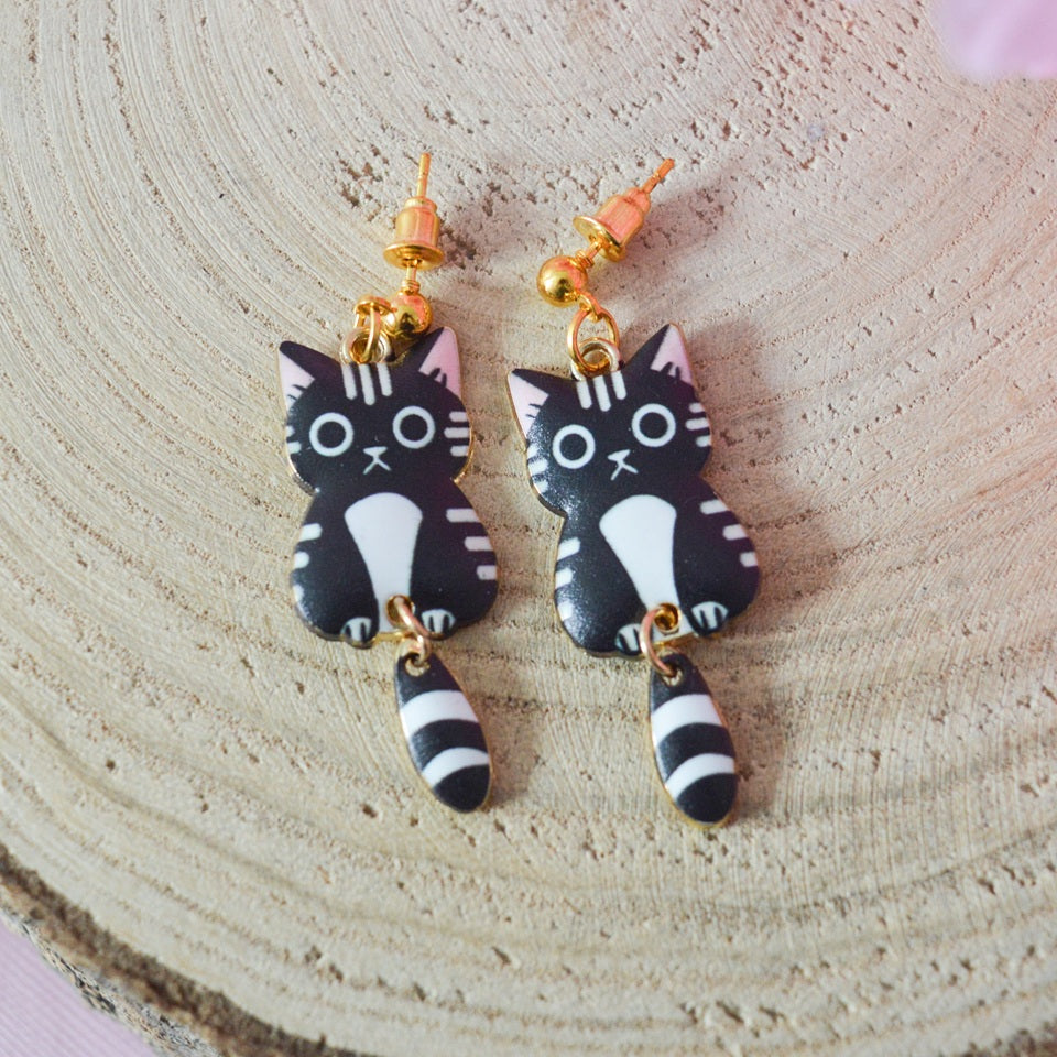 des boucles d'oreilles en forme de chat de toutes les couleurs. Ils ont la queue qui pend indépendamment de leur corps. Ils sont vraiment mignons et stylés