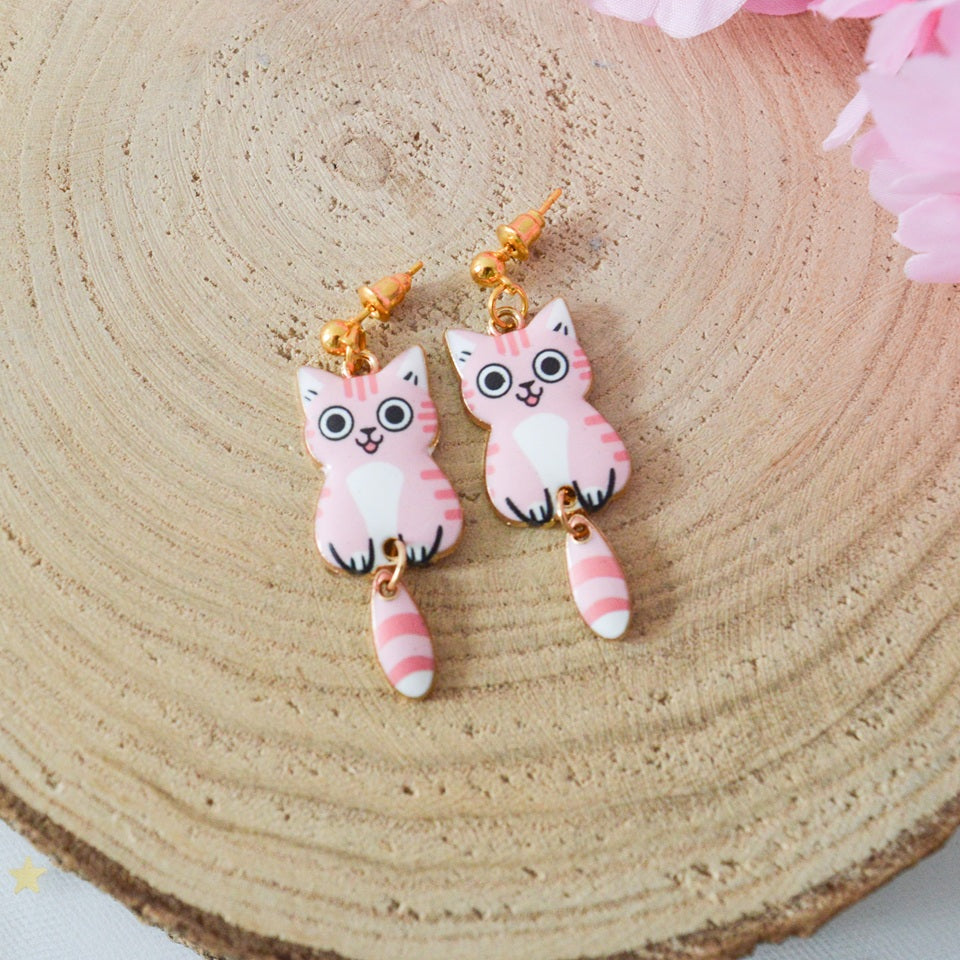 des boucles d'oreilles en forme de chat de toutes les couleurs. Ils ont la queue qui pend indépendamment de leur corps. Ils sont vraiment mignons et stylés
