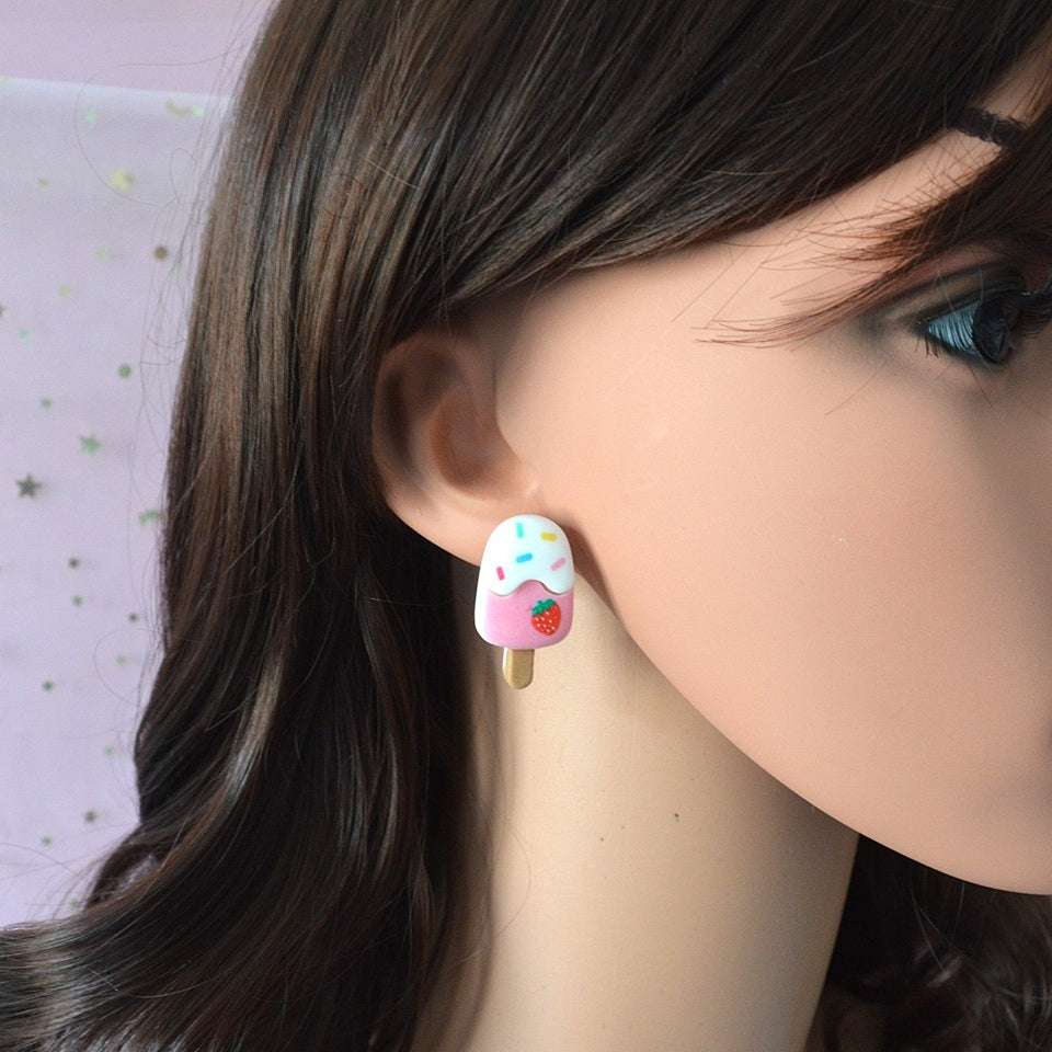 une paire de boucles d'oreilles en forme de glaces et de cônes gourmands et colorés. Design hyper kawaii