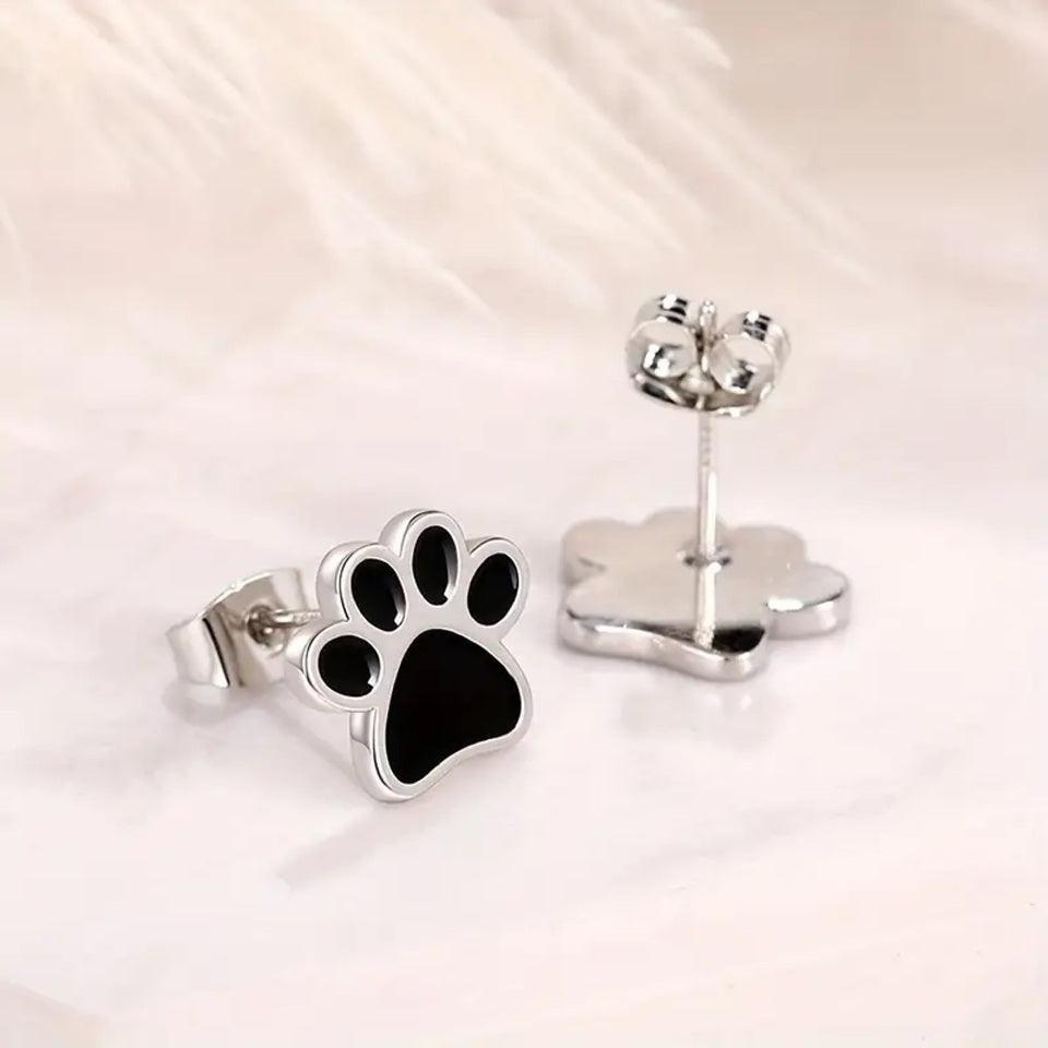 une paire de puces d'oreilles en forme de patte de chat noir.