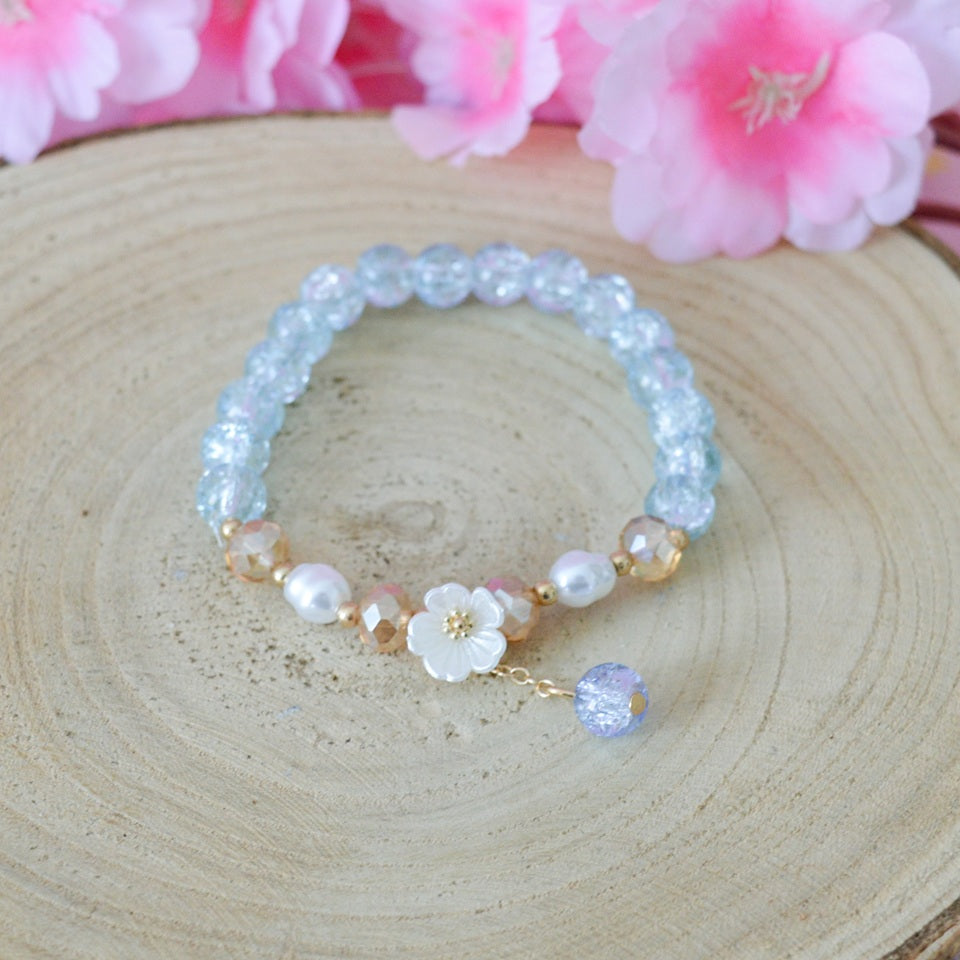 des bracelets romantiques de perles colorées accompagnées d'une délicate fleur de sakura blanche. Style bohème kawaii, romantique, bracelet élastique