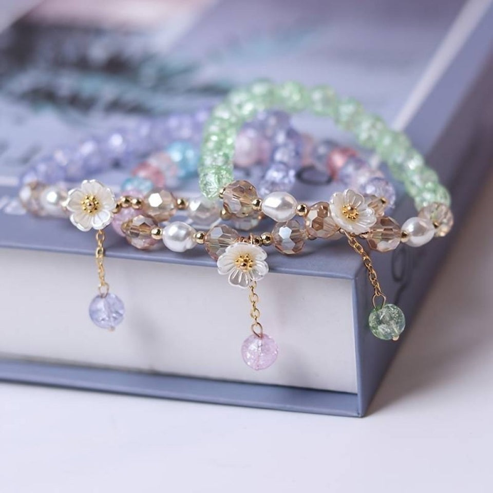 des bracelets romantiques de perles colorées accompagnées d'une délicate fleur de sakura blanche. Style bohème kawaii, romantique, bracelet élastique