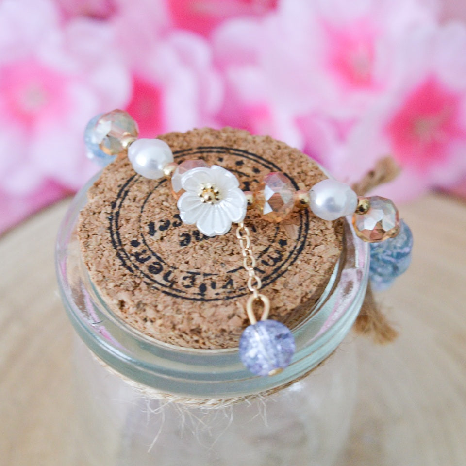 des bracelets romantiques de perles colorées accompagnées d'une délicate fleur de sakura blanche. Style bohème kawaii, romantique, bracelet élastique