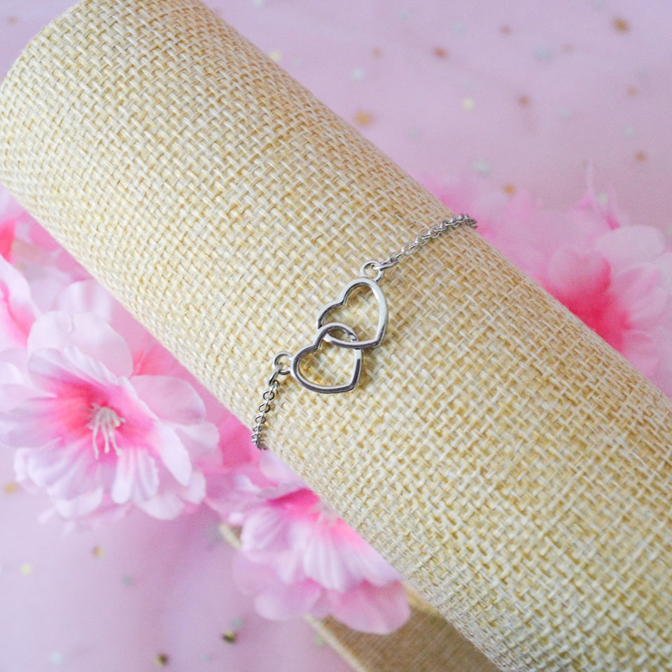 un bracelet argenté représenté deux coeurs entrelacés. Symbole d'amour, d'union éternel