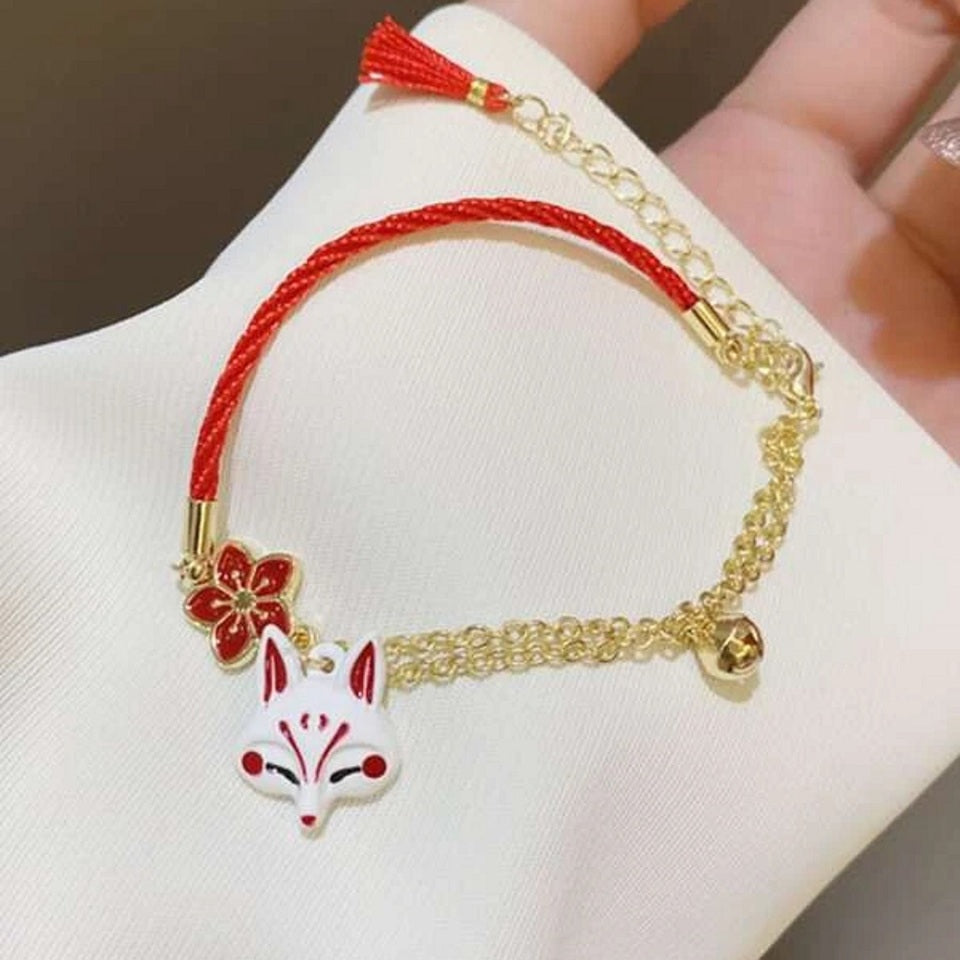un bracelet kistune, une fleur de sakura rouge, une clochette adorable, le tout en coloris rouge et blanc. Harmonie parfaite. Inspiration du Japon