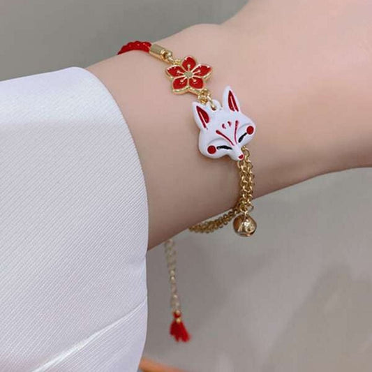 un bracelet kistune, une fleur de sakura rouge, une clochette adorable, le tout en coloris rouge et blanc. Harmonie parfaite. Inspiration du Japon