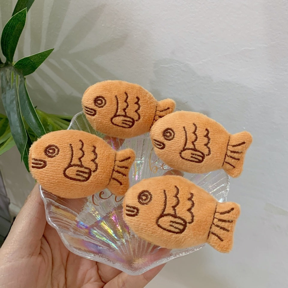 une broche en forme de poisson comme un taiyaki. Tout en peluche, elle est très douce et mignonne.