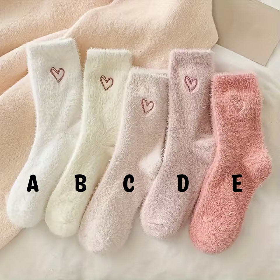 des paires de chaussettes toutes douces en matière pilou dans les tons roses et blancs. Sur le haut de la chaussette, un joli coeur rose est imprimé. Style féminin adorable, idéal pour les soirées cocooning !