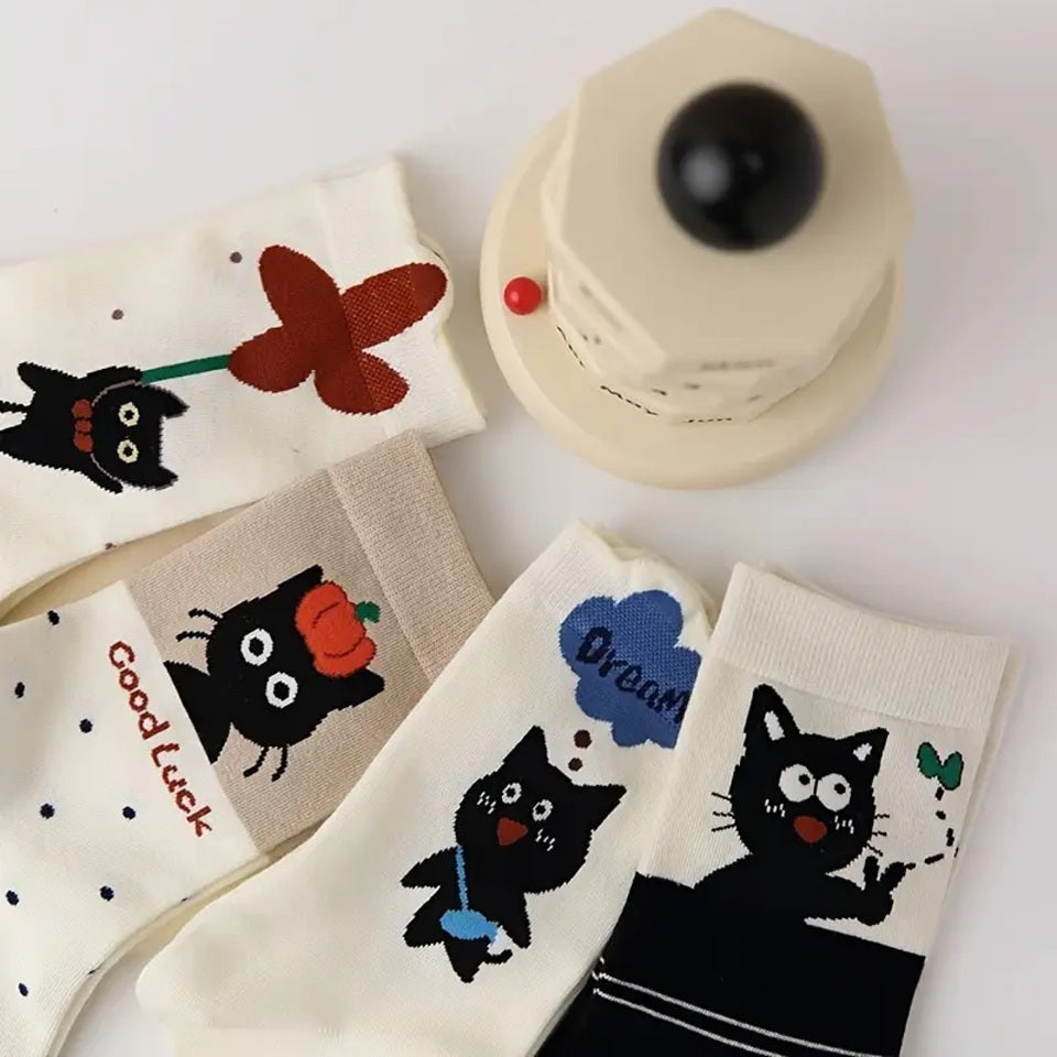 des chaussettes en coton toutes douces au motif d'un chat noir dans différentes situations adorables. Certains ont un motif de pois, d'autres de lignes.