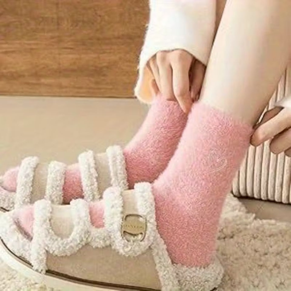 des paires de chaussettes toutes douces en matière pilou dans les tons roses et blancs. Sur le haut de la chaussette, un joli coeur rose est imprimé. Style féminin adorable, idéal pour les soirées cocooning !