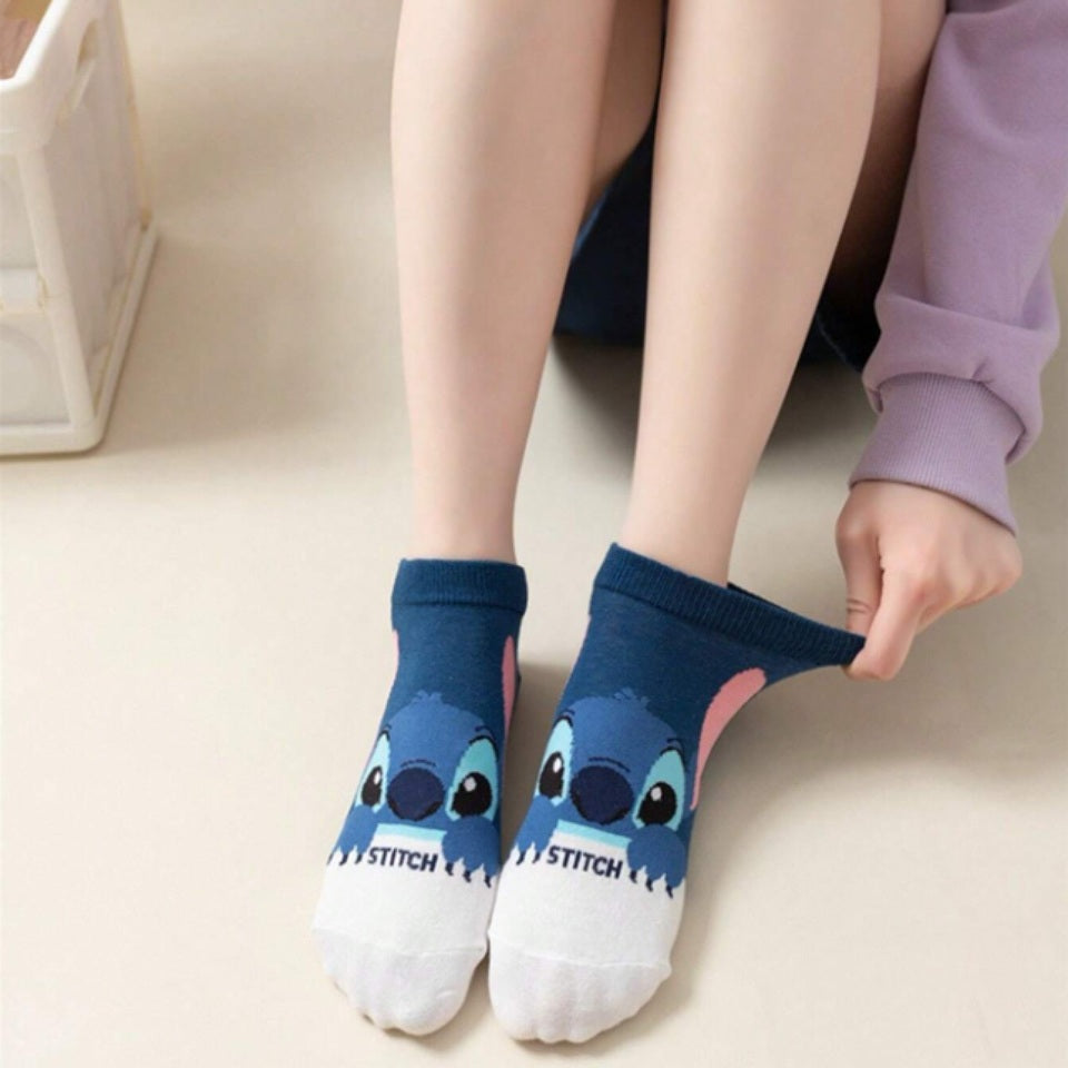 des chaussettes taille unique au design inspiré de Stitch de Lilo et Stitch.Dans les tons bleus, bancs et noirs, ces chaussettes sont toutes douces et on retrouve Stitch dans différentes poses et expressions toutes mignonnes.