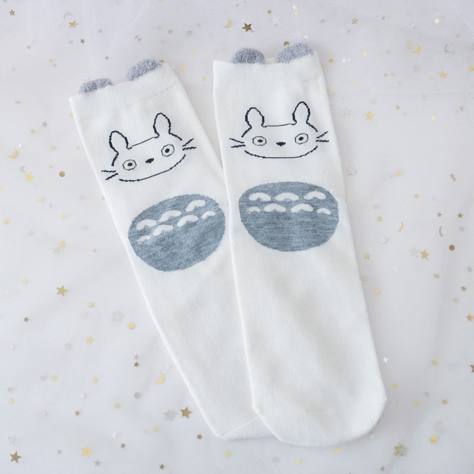 des chaussettes en coton toutes douces et mignonnes inspirées du personnage Totoro du film Mon voisin Totoro. Elles reprennent le design de ce personnage si charismatique et tendre. Retrouvez les chaussettes en coloris blanc, brun, bleu et gris.