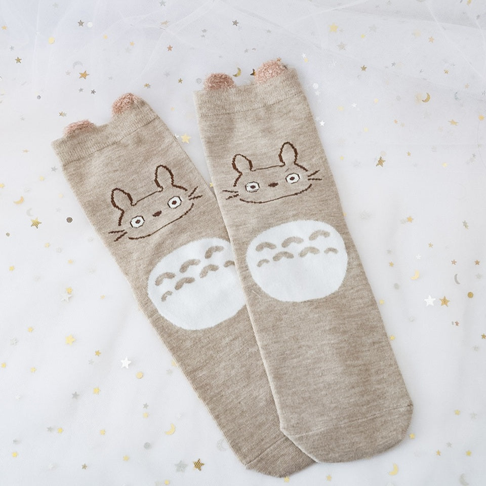 des chaussettes en coton toutes douces et mignonnes inspirées du personnage Totoro du film Mon voisin Totoro. Elles reprennent le design de ce personnage si charismatique et tendre. Retrouvez les chaussettes en coloris blanc, brun, bleu et gris.