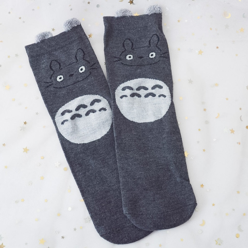 des chaussettes en coton toutes douces et mignonnes inspirées du personnage Totoro du film Mon voisin Totoro. Elles reprennent le design de ce personnage si charismatique et tendre. Retrouvez les chaussettes en coloris blanc, brun, bleu et gris.