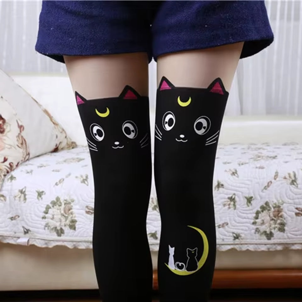 une paire de collants noirs sur lesquels est imprimé le visage expressif et mignon du chat noir Luna dans Sailormoon. On retrouve ses petites oreilles ainsi qu'un croissant de lune au niveau de la jambe sur lequel est posé le chat noir lune et le chat blanc artemis.