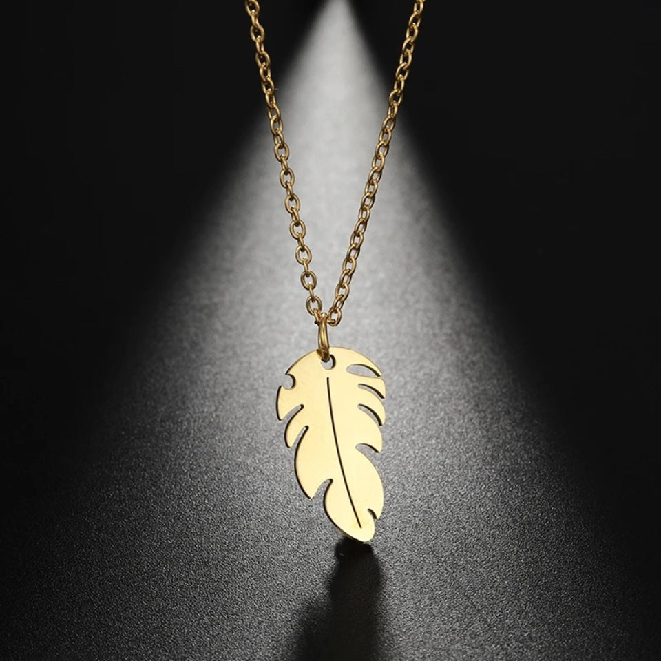 un collier doré dont le pendentif représente une petite plume. Symbole de liberté et de légèreté
