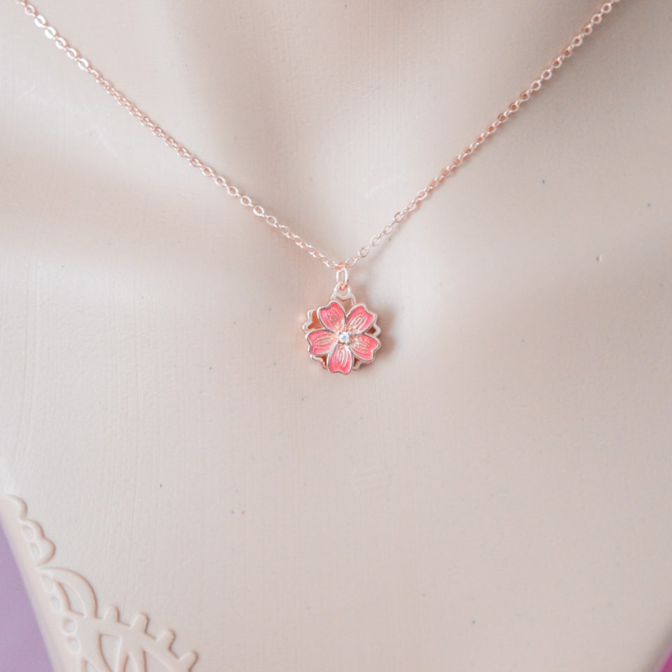 un collier dont le pendentif représente une jolie fleur de sakura rose que l'on peut faire tourner. Son effet rotatif permet de s'apaiser et a un effet anti stress
