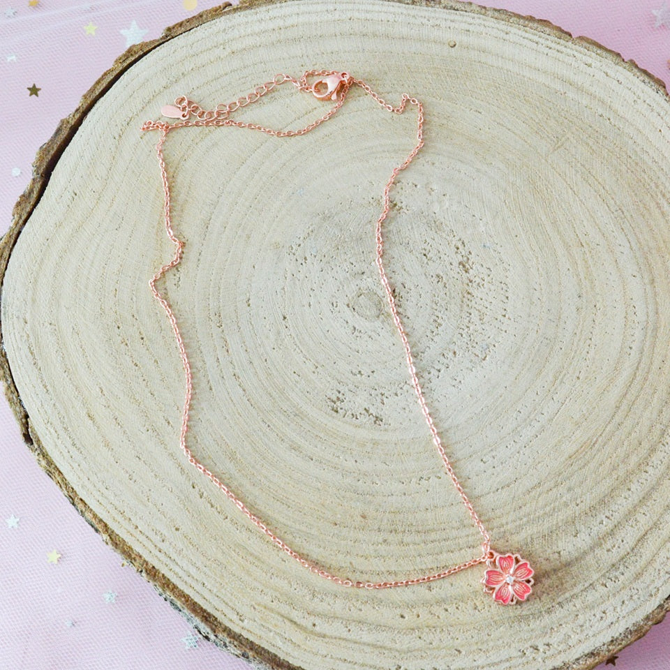 un collier dont le pendentif représente une jolie fleur de sakura rose que l'on peut faire tourner. Son effet rotatif permet de s'apaiser et a un effet anti stress
