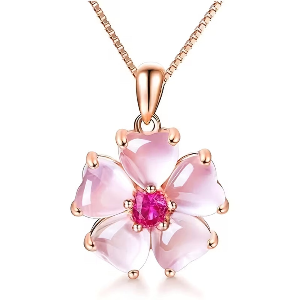 un superbe collier rose gold dont le pendentif est une jolie fleur de sakura aux pétales roses et dont le coeur est un strass rose brillant. Le bijou est élégant et romantique et rappelle la saison des sakura en fleurs au Japon.