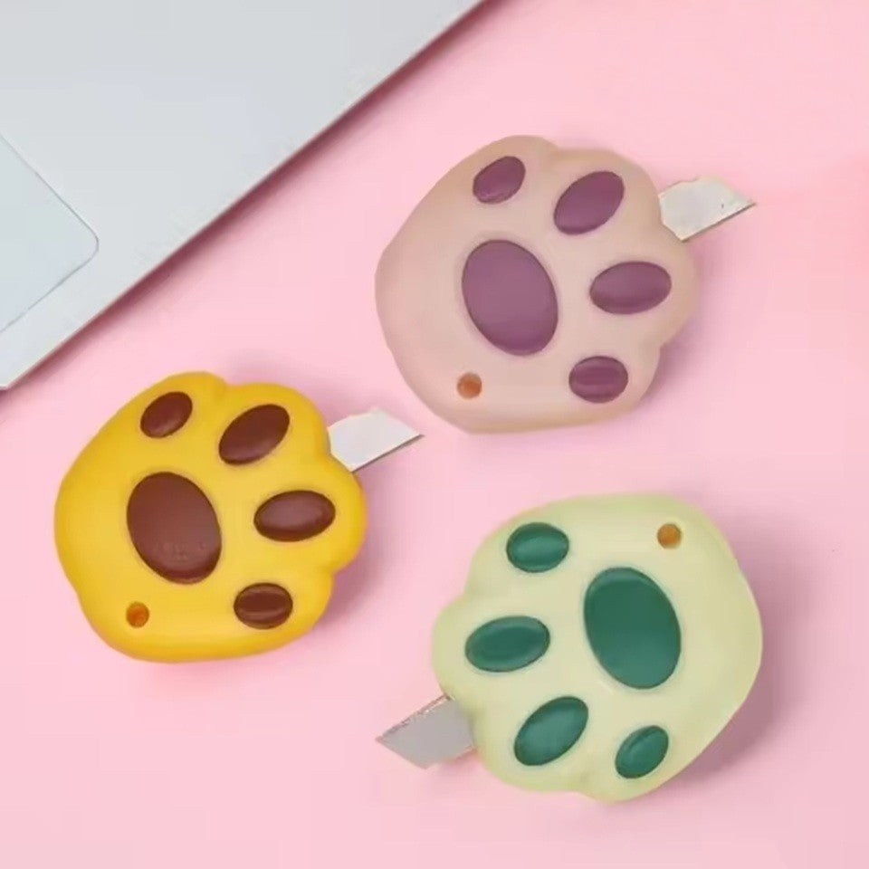 des cutters en forme de patte de chat colorés. Les coussinets sont représentés et ajoutent une touche de réalisme et de mignonnerie à cet accessoire de découpe