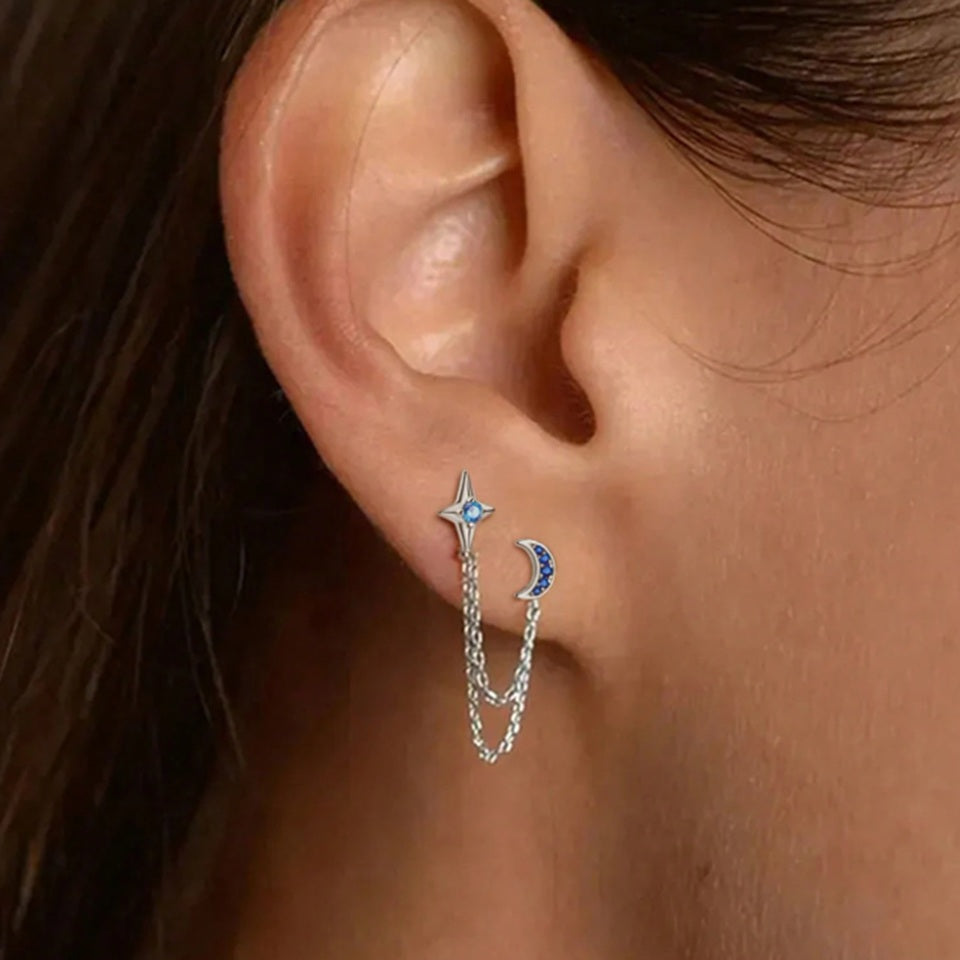 une paire de double boucles d'oreilles croissant de lune et étoile tout en strass relié par deux chainettes argentées