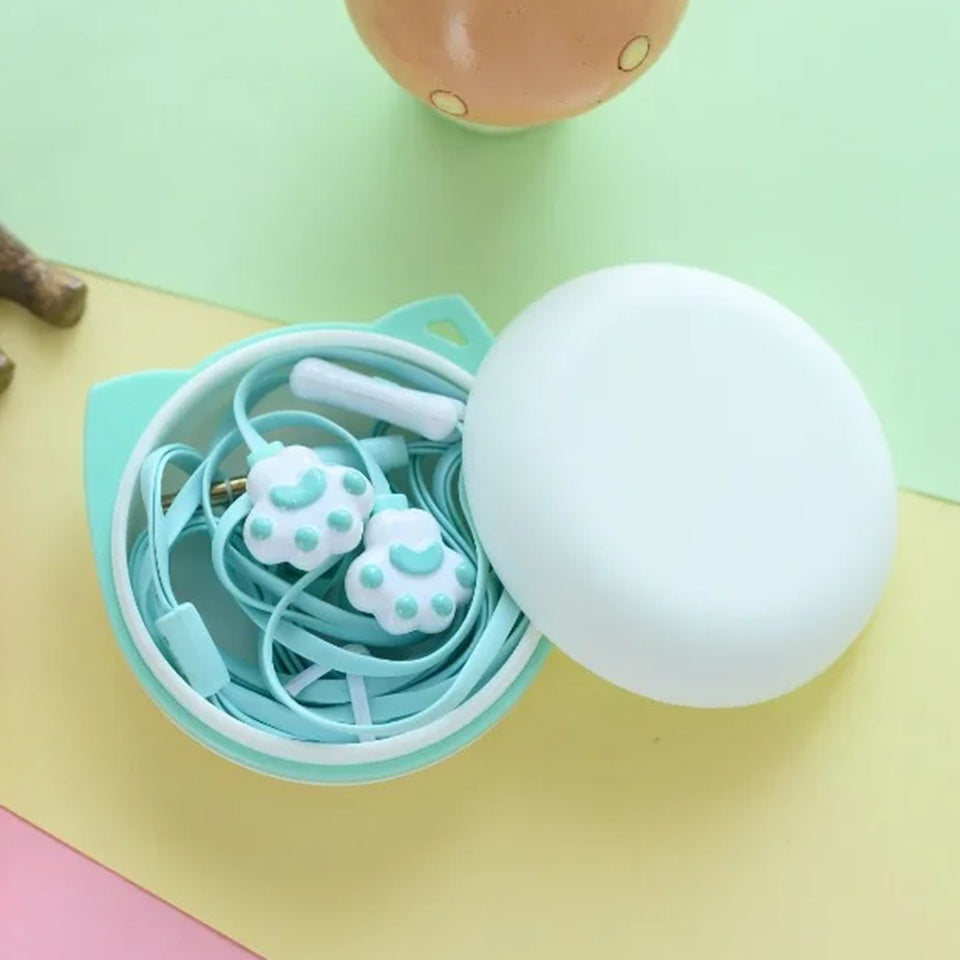 des écouteurs en forme de patte d'animaux en coloris vert. Hyper mignons, ils peuvent être rangés dans leur étui oreilles de chat. L'ensemble est trop mignon et hyper pratique.