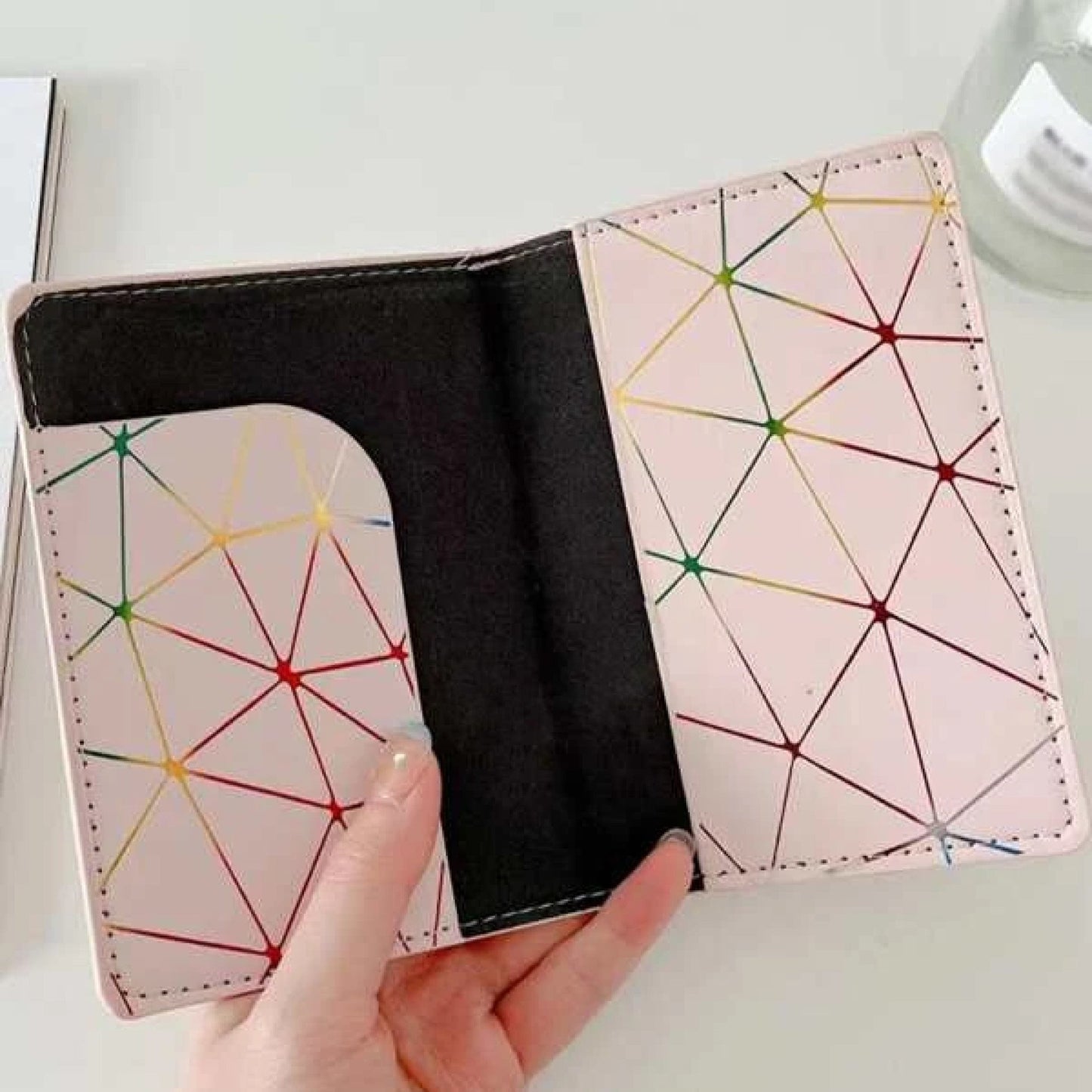 un étui au motif de lignes géométriques néon et multicolores pour y ranger le passeport. il protège votre document et ajoute une touche stylé.