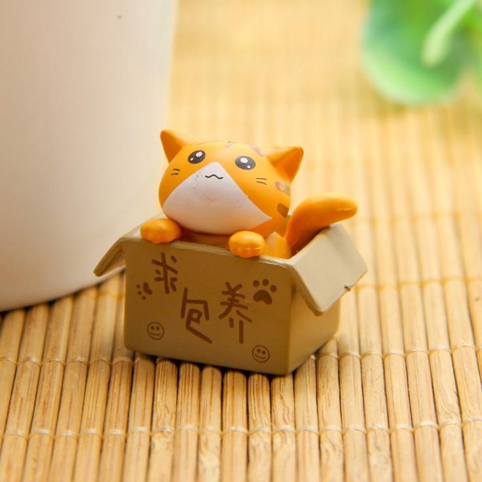 des figurines de chat bien lovés dans leur boite en carton : gris, noir, blanc ou roux, ils sont adorables. Parfait pour décorer une pièce avec style et mignonnerie