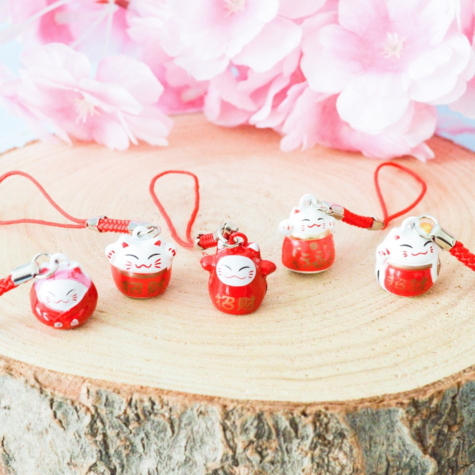 des porte-clés en forme de maneki neko sous forme de grelot. Il y a plusieurs couleurs et designs différents.