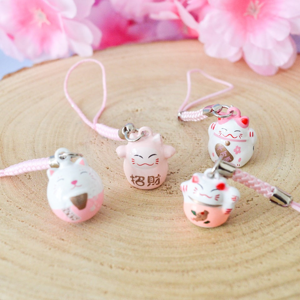 des porte-clés en forme de maneki neko sous forme de grelot. Il y a plusieurs couleurs et designs différents.