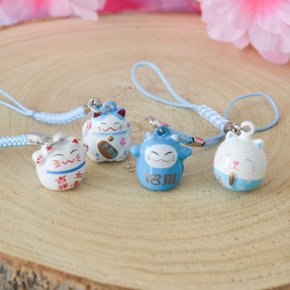 des porte-clés en forme de maneki neko sous forme de grelot. Il y a plusieurs couleurs et designs différents.