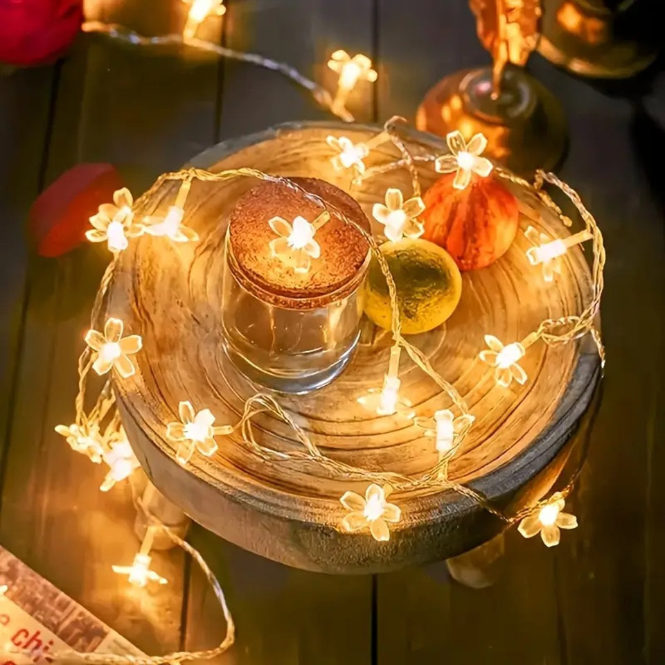 une guirlande LED en forme de fleurs de sakura toutes mignonnes. Elle diffuse une lumière jaune chaude et chaleureuse. Idéale pour créer une ambiance cocooning